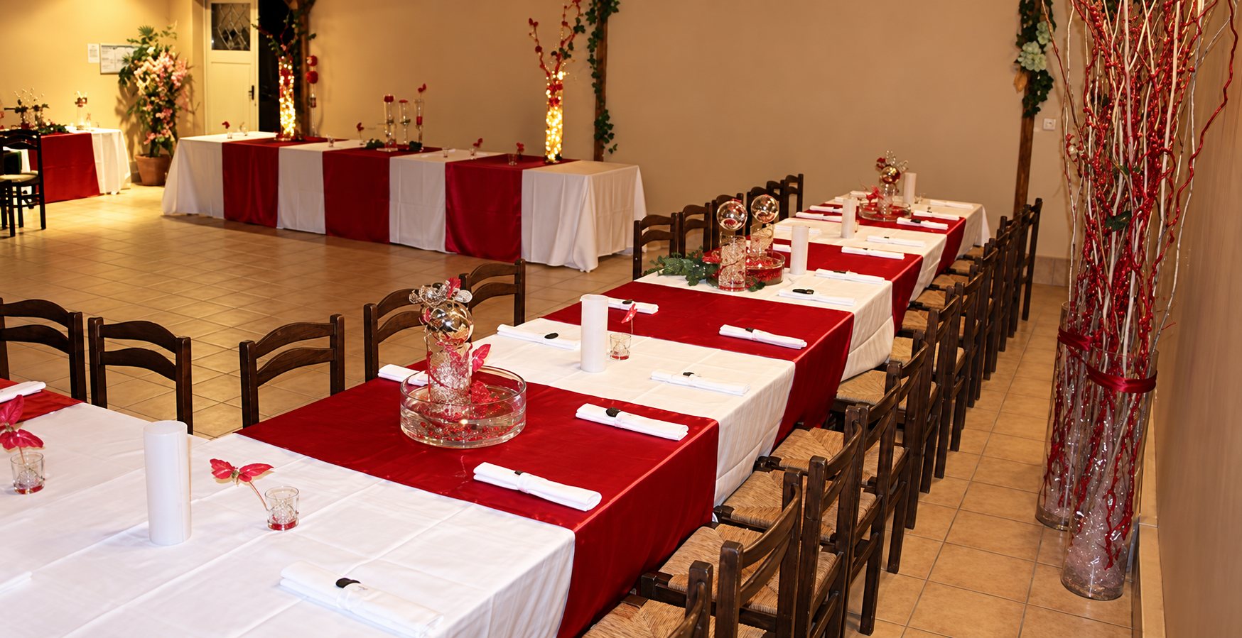 Salle de la Prairie : longues tables dressées avec chemins de table rouges